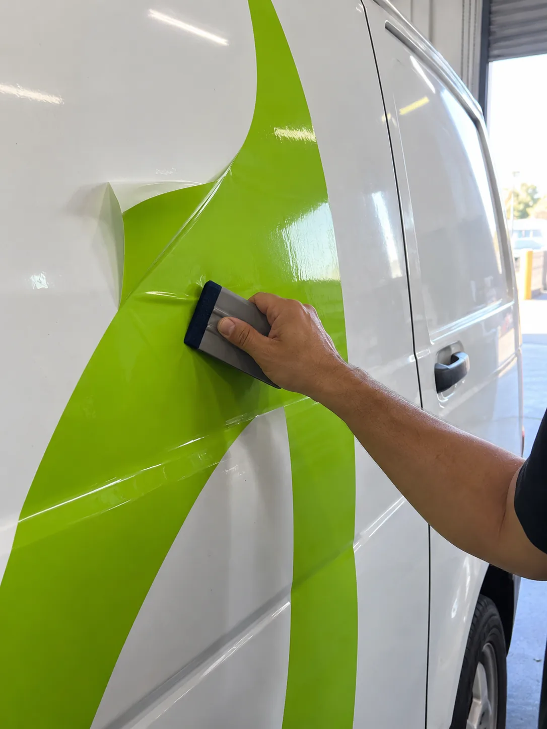 Applying lime vinyl to a white van